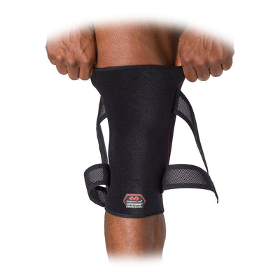 McDavid Cross Compression™ Knee Sleeve with Adjustable Compression Straps - Black - On Model - Pulling Knee Sleeve Over Knee