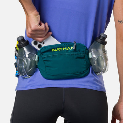 color:Deep Teal/Finish Lime||seo:Nathan TrailMix Plus Hydration Belt 3.0 - Deep Teal/Finish Lime - Model Pulling Cell Phone From Pocket