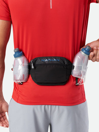 color:Black/Deep Blue||view:sku image back||seo:Nathan TrailMix Plus Insulated Hydration Belt 3.0 - Black/Deep Blue - On Model - Pulling Flask From Carrier
