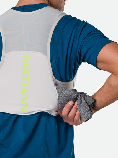 color:Vapor Grey||seo:Nathan Pinnacle FeatherLite 1.5 Liter Unisex Hydration Vest - Vapor Grey - Male Runner Pulling Long Sleeve Shirt from Back Kangaroo Pocket