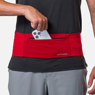 color:Ribbon Red/Reflective Silver||seo: Nathan Zipster Max Training Waist Belt - Ribbon Red/Reflective Silver - Model Pulling Out iPhone From Storage Pocket