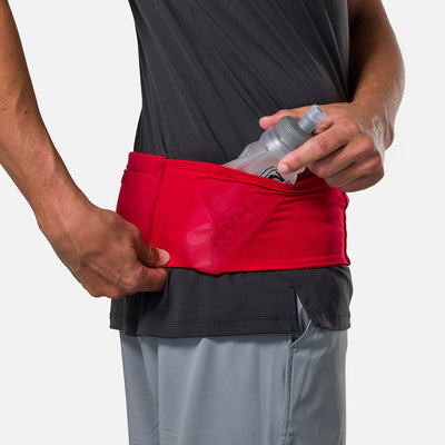 color:Ribbon Red/Reflective Silver||seo: Nathan Zipster Max Training Waist Belt - Ribbon Red/Reflective Silver - Model Pulling Hydration Flask Out of Side Storage Pocket