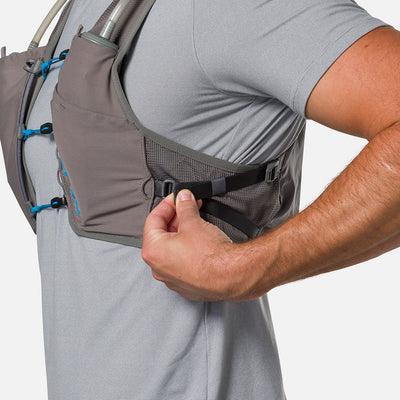 color:Charcoal/Electric Blue||seo:Nathan Pinnacle Breeze 4 Liter Unisex Hydration Race Vest - Charcoal/Electric Blue - Model Adjusting QuickFit Size System to Adjust Around His Body