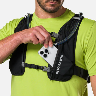 color:Black/Reflective Silver||seo:Nathan QuickStart 3.0 4 Liter Hydration Pack - Black/Reflective Silver - On Model - Model Pulling iPhone From Front Zippered Pocket