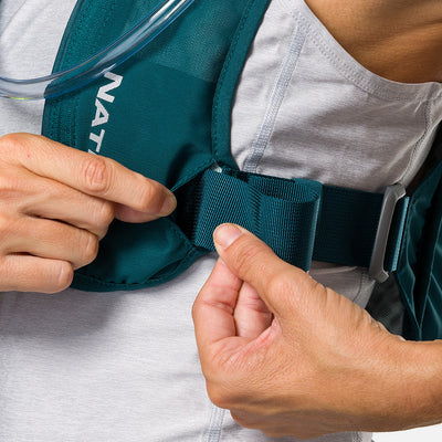 color:Deep Teal/Reflective Silver||seo:Nathan QuickStart 3.0 4 Liter Hydration Pack - Deep Teal/Reflective Silver - On Model - Closeup Detail View of Model Adjusting Wide Side Straps For a Secure No Bounce Fit