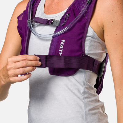 color:Imperial Purple/Reflective Silver||seo:Nathan QuickStart 3.0 4 Liter Hydration Pack - Imperial Purple/Reflective Silver - On Model - Model Adjusting Wide Side Straps For a Secure No Bounce Fit