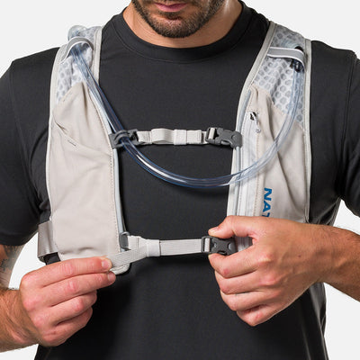 color:Vapor Grey/Deep Blue||seo:Nathan QuickStart 3.0 4 Liter Hydration Pack - Vapor Grey/Deep Blue - On Model - Model Tightening Sternum Straps For Better Fit
