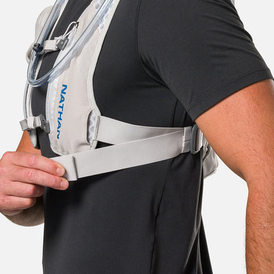color:Vapor Grey/Deep Blue||seo:Nathan QuickStart 3.0 4 Liter Hydration Pack - Vapor Grey/Deep Blue - On Model - Model Adjusting Wide Side Straps For a Secure No Bounce Fit