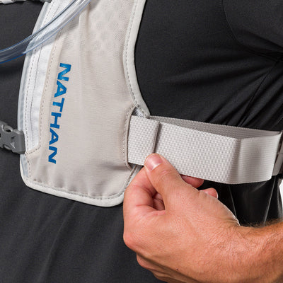 color:Vapor Grey/Deep Blue||seo:Nathan QuickStart 3.0 4 Liter Hydration Pack - Vapor Grey/Deep Blue - On Model - Closeup Detail View of Model Adjusting Wide Side Straps For a Secure No Bounce Fit
