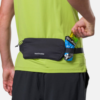 color:Black/Reflective Silver||seo:Nathan Marathon Waist Pack 3.0 - Black/Reflective Silver - On Model - Pulling Glukos Energy Gel (Lemon Lime Flavor) From Keeper