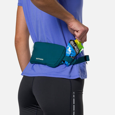 color:Deep Teal/Surf Spray||seo:Nathan Marathon Waist Pack 3.0 - Deep Teal/Surf Spray - On Model - Pulling Glukos Energy Gel (Lemon Lime Flavor) From Keeper
