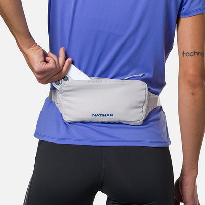 color:Vapor Grey/Sailor Blue||seo:Nathan Marathon Waist Pack 3.0 - Vapor Grey/Sailor Blue - On Model - Pulling iPhone Phone From Storage Pocket