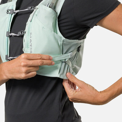 color:Surf Spray/Reflective Silver||seo:Nathan Pinnacle Breeze 4 Liter Women's Hydration Race Vest - Surf Spray/Reflective Silver - Model Adjusting QuickFit Size System to Adjust Around Her Body