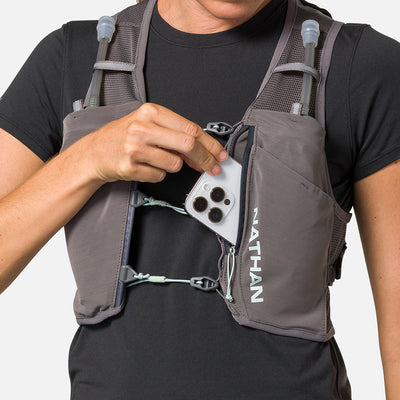 color:Charcoal/Surf Spray||seo:Nathan Pinnacle Breeze 4 Liter Women's Hydration Race Vest - Charcoal/Surf Spray - Female Runner Pulling iPhone From Front Storage Pocket