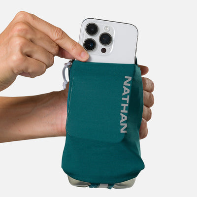 color:Deep Teal/Reflective Silver||seo:Nathan SpeedDraw 2 18oz Flask - Deep Teal/Reflective Silver - Model Pulling iPhone from Front Pouch