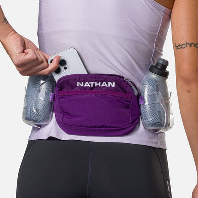 color:Imperial Purple/Paisley Purple||seo:Nathan TrailMix Plus Insulated Hydration Waist Belt 3.0 - Imperial Purple/Paisley Purple - On Model - Pulling Cell Phone From Pocket