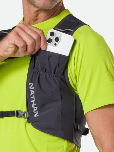 color:Charcoal/Reflective Silver||seo:Nathan Pinnacle FeatherLite 1.5 Liter Unisex Hydration Vest - Charcoal/Reflective Silver - Male Runner Pulling iPhone From Front Storage Pocket