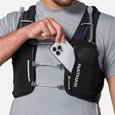 color:Black/Reflective Silver||seo:Nathan Pinnacle Pro 6 Liter Unisex Hydration Race Vest - Black/Reflective Silver - Male Runner Pulling iPhone From Front Storage Pocket