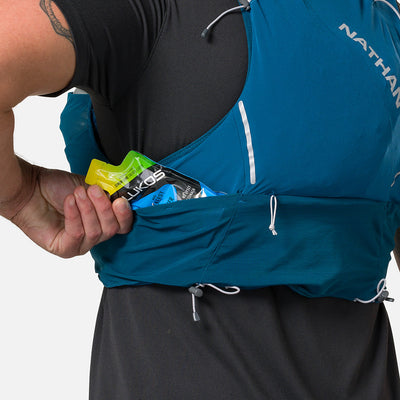 color:Sailor Blue/Reflective Silver||seo:Nathan Pinnacle Pro 6 Liter Unisex Hydration Race Vest - Sailor Blue/Reflective Silver - Male Runner Pulling Glukos Energy Gel (Lemon Lime Flavor) From Easy-Access Kangaroo Pocket
