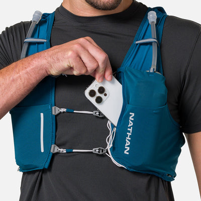 color:Sailor Blue/Reflective Silver||seo:Nathan Pinnacle Pro 6 Liter Unisex Hydration Race Vest - Sailor Blue/Reflective Silver - Male Runner Pulling iPhone From Front Storage Pocket