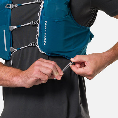 color:Sailor Blue/Reflective Silver||seo:Nathan Pinnacle Pro 6 Liter Unisex Hydration Race Vest - Sailor Blue/Reflective Silver - Model Adjusting QuickFit Size System to Adjust Around His Body