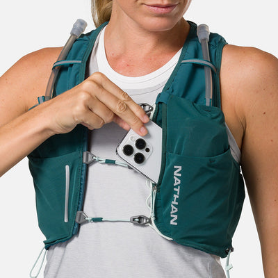 color:Deep Teal/Reflective Silver||seo:Nathan Pinnacle Pro 6 Liter Women's Hydration Race Vest - Deep Teal/Reflective Silver - Female Runner Pulling iPhone From Front Storage Pocket