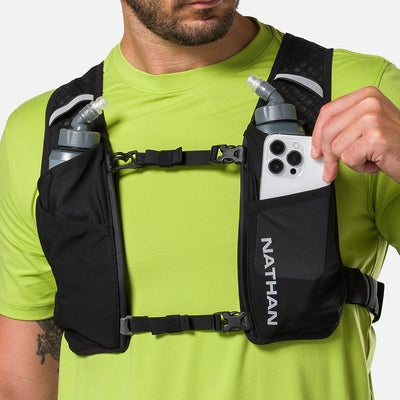 color:Black/Reflective Silver||seo:Nathan QuickStart 3.0 4 Liter Soft Flask Hydration Pack - Black/Reflective Silver - On Model - Model Pulling iPhone From Front Zippered Pocket