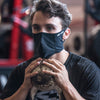 Black Play Safe Face Mask Lifestyle Image – Male Model Wearing Protective Safety Face Mask in the Gym while doing Squats - Left Angle